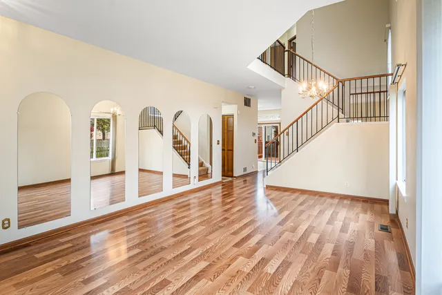 a view of a hallway with wooden floor and stairs