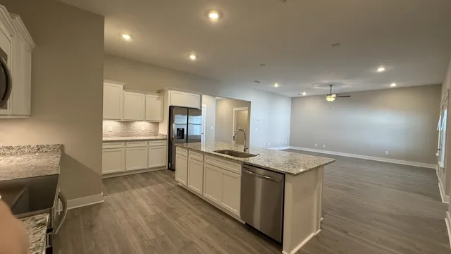 a kitchen with stainless steel appliances granite countertop a sink a stove and a refrigerator