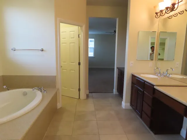 a spacious bathroom with a bathtub sink and mirror