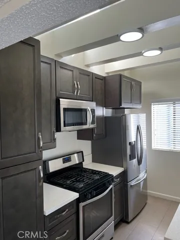 a kitchen with stainless steel appliances granite countertop a refrigerator and a stove top oven