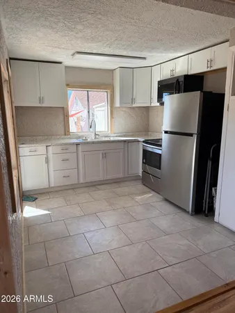 a kitchen with a stove a refrigerator and a sink