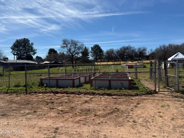 a view of swimming pool with lawn chairs and wooden fence