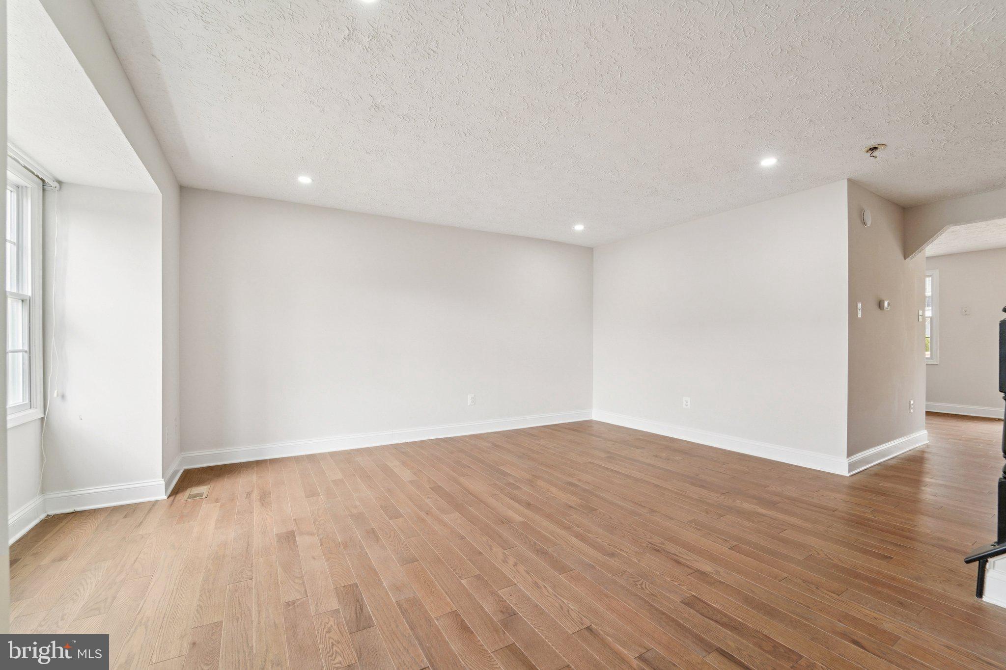 8727 Silver Hall Road Perry Hall, MD 21128 - Photo 3 of 35 a view of an empty room with wooden floor and a window