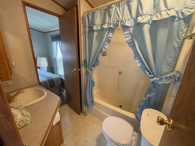 a bathroom with a granite countertop sink toilet and shower