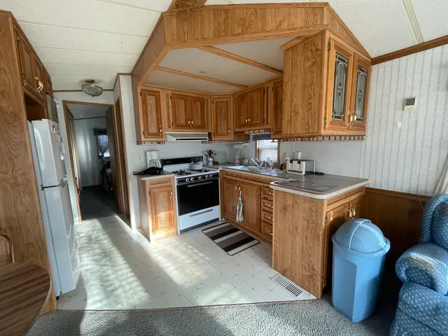 a kitchen with stainless steel appliances granite countertop a stove a sink dishwasher a refrigerator and cabinets