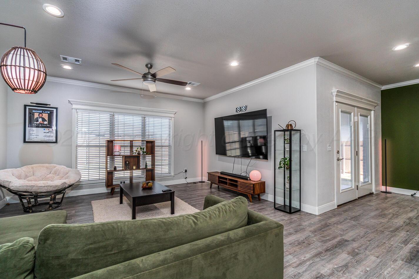 7500 Crestline Drive Amarillo, TX 79119 - Photo 11 of 24 a living room with furniture a flat screen tv and a window
