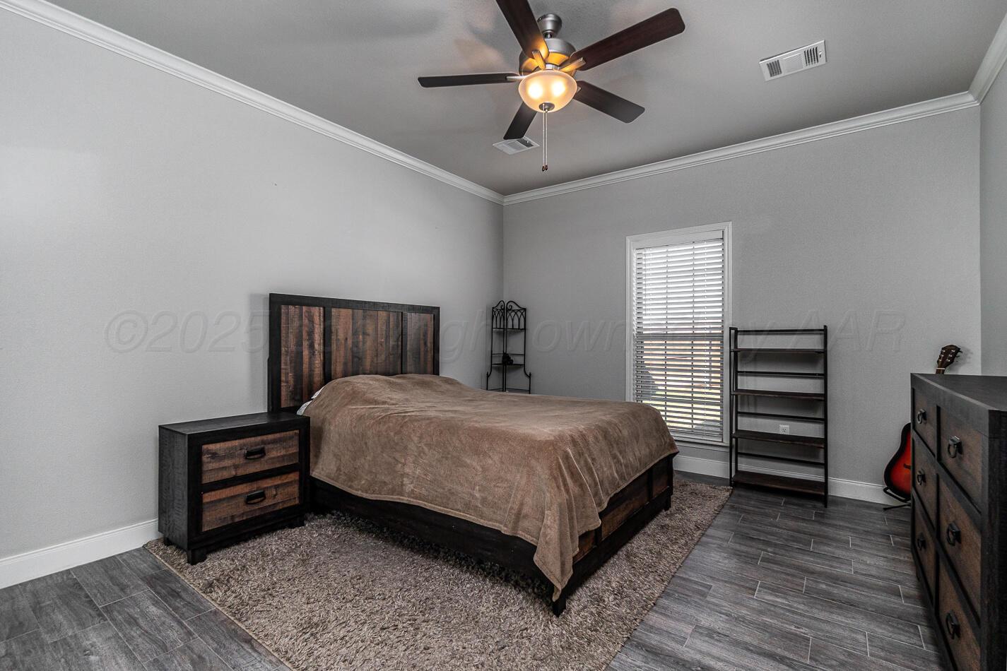 7500 Crestline Drive Amarillo, TX 79119 - Photo 14 of 24 a bedroom with a bed and a chandelier