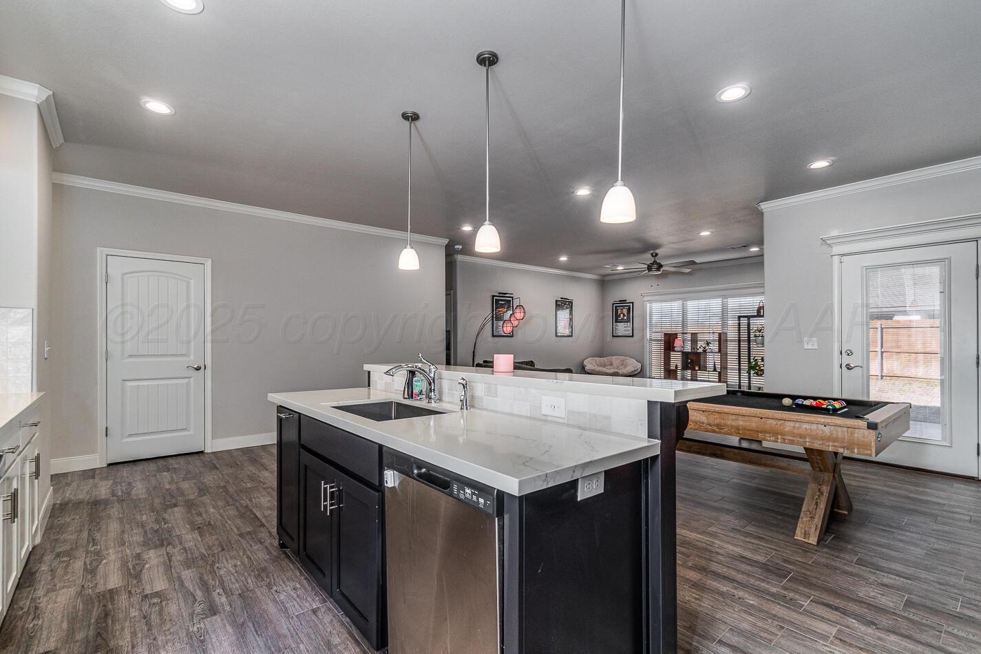 7500 Crestline Drive Amarillo, TX 79119 - Photo 9 of 24 a kitchen with a stove a sink a center island and wooden floor