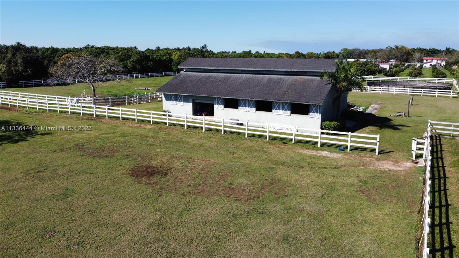 Redlands Homestead, FL 33031 - Photo 4 of 35 a view of a large pool with lawn chairs under an umbrella