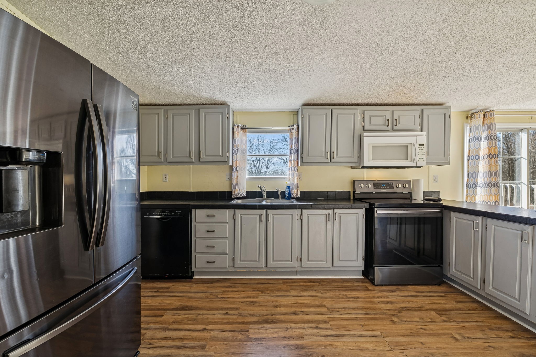 217 Tomlinson Road Lebanon, TN 37087 - Photo 9 of 23 a kitchen with granite countertop a refrigerator cabinets and wooden floor