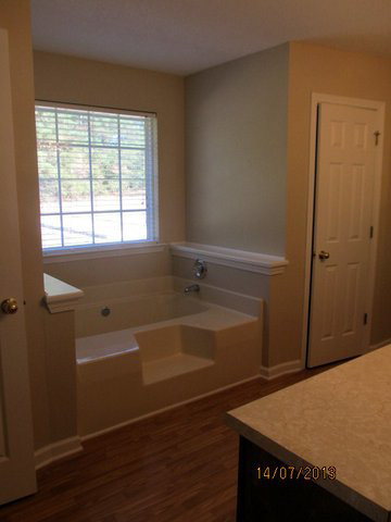 437 Comer Road Gray, GA 31032 - Photo 16 of 20 a bathroom with a bathtub and a window