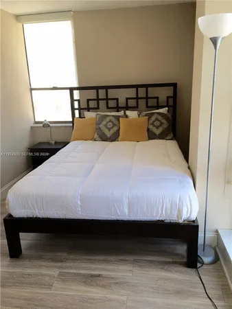 a large bed sitting in a bedroom next to a window