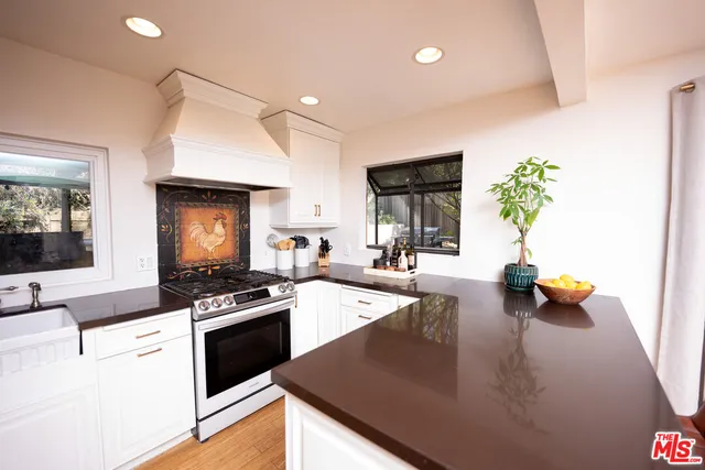 a kitchen with a sink a stove and cabinets
