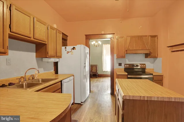 a kitchen with refrigerator a stove a sink and cabinets