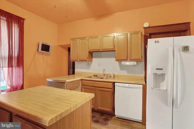 a kitchen with a stove a refrigerator and a sink