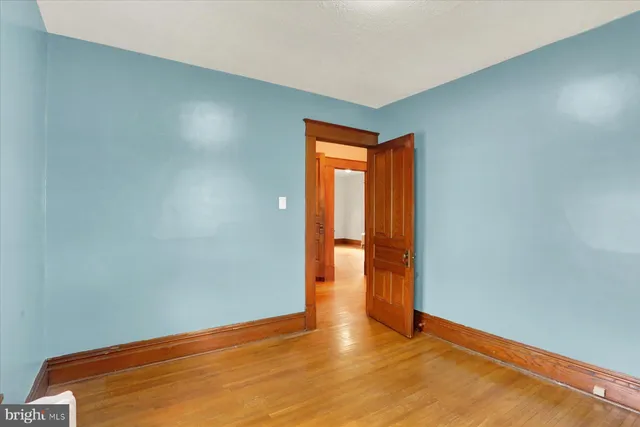 an empty room with wooden floor and yard