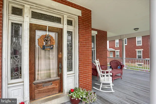 a porch area with a table and chairs