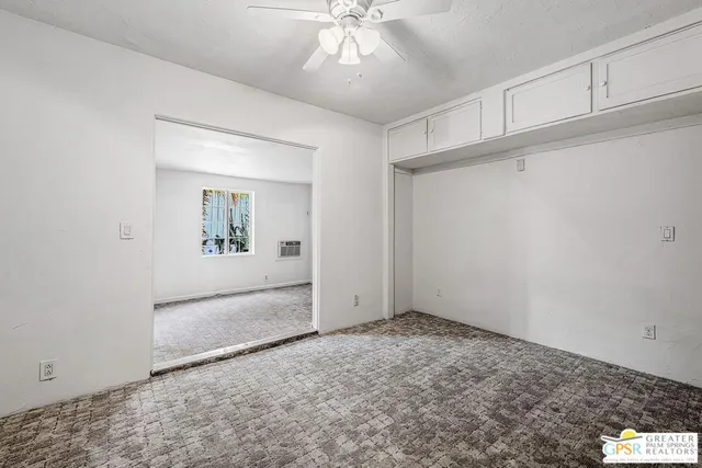 an empty room with fan and windows