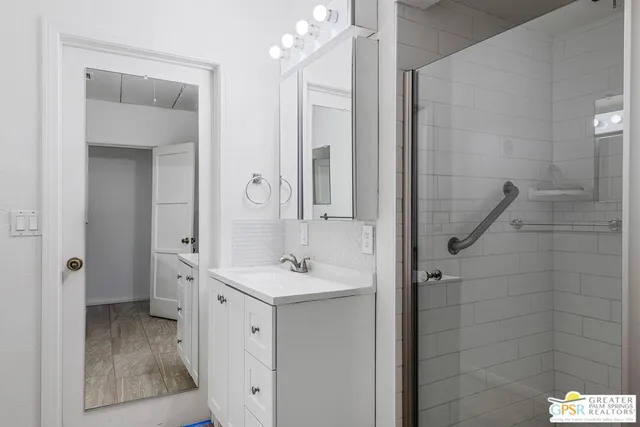 a spacious bathroom with a granite countertop sink a mirror and a shower