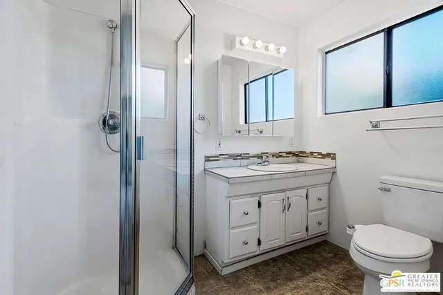 a bathroom with a granite countertop toilet sink and a mirror