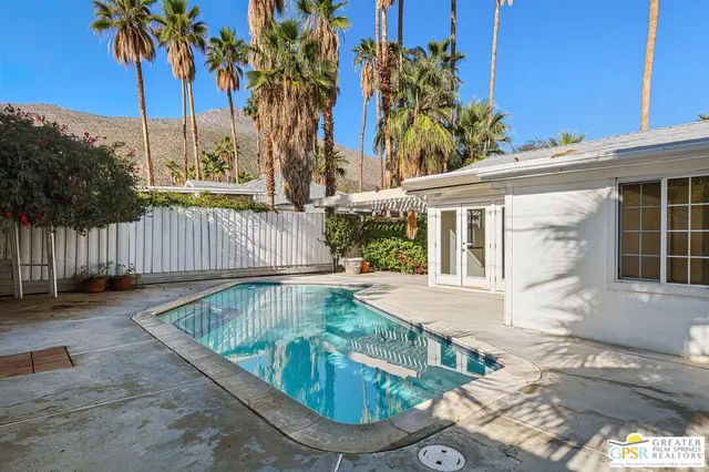 front view of house with a yard and potted plants