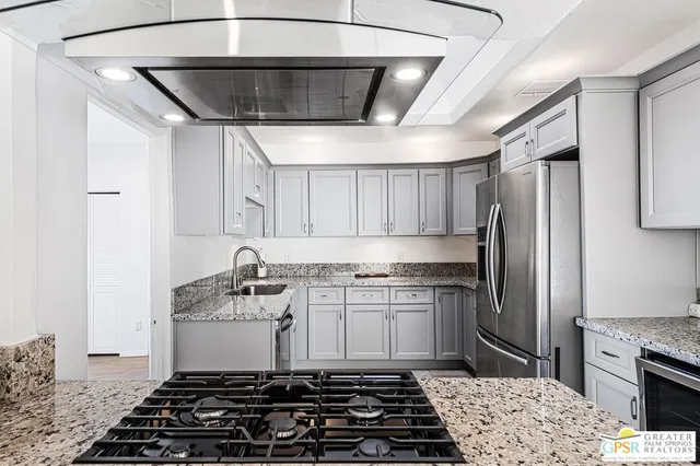 a kitchen with stainless steel appliances granite countertop a sink stove and refrigerator