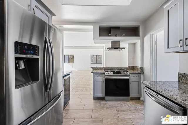 a kitchen with stainless steel appliances granite countertop a refrigerator and a stove