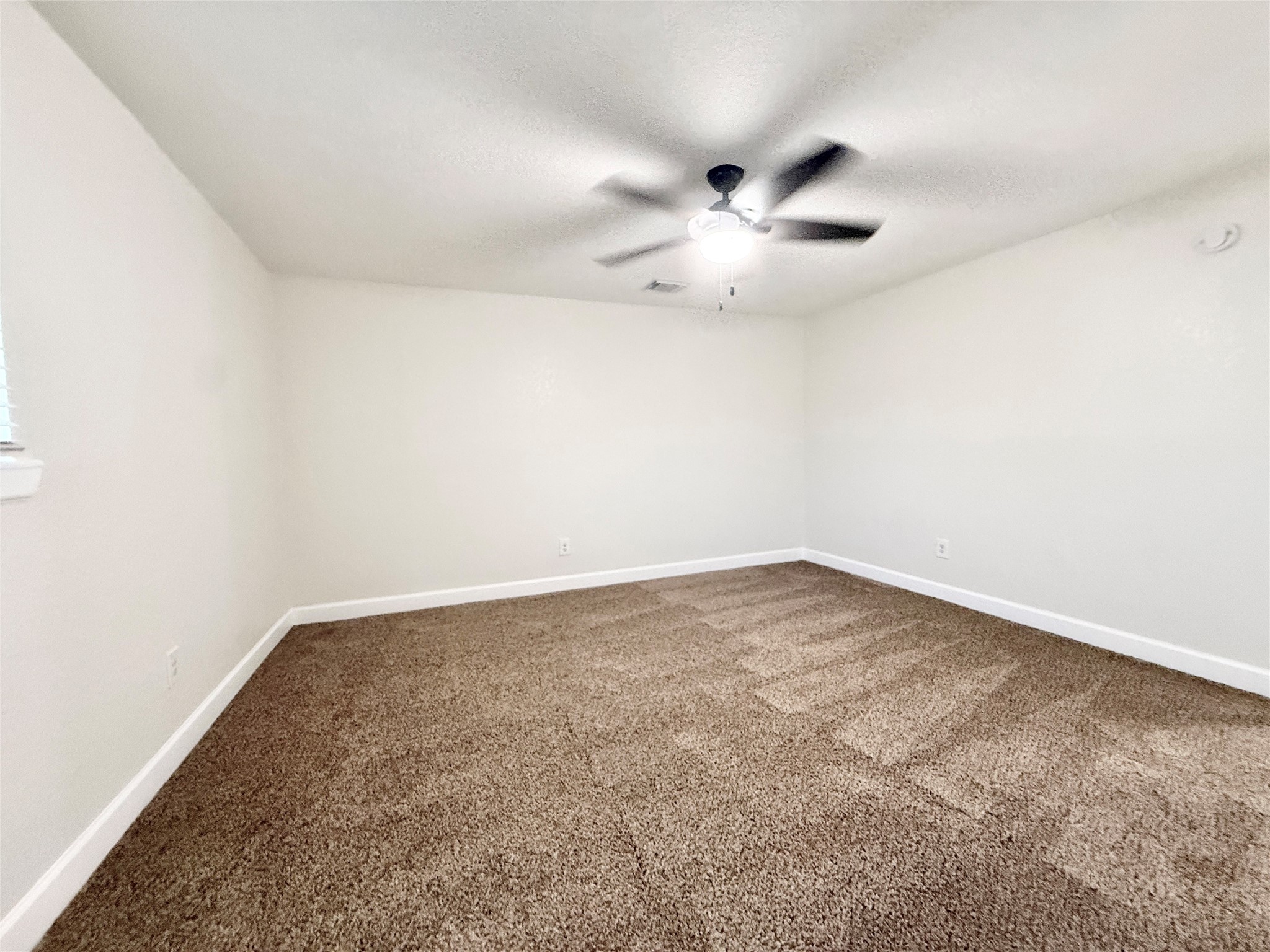 1429 Northview Drive Angleton, TX 77515 - Photo 15 of 29 an empty room with a window and ceiling fan