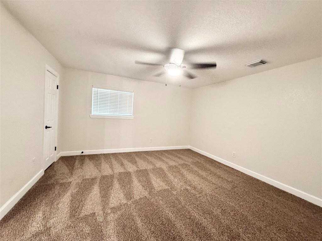1429 Northview Drive Angleton, TX 77515 - Photo 16 of 29 an empty room with a ceiling fan and a window