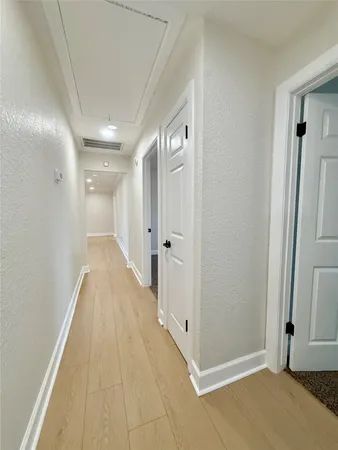 a view of a hallway with wooden floor