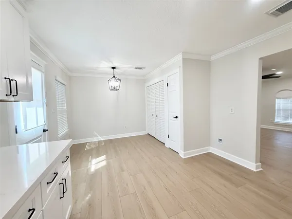 a view of an empty room with wooden floor