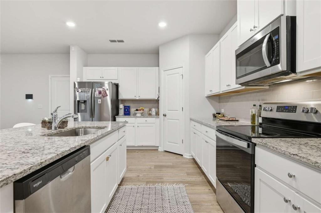 7129 Timberland Trail Lithonia, GA 30058 - Photo 29 of 43 a kitchen with stainless steel appliances granite countertop a sink stove and refrigerator