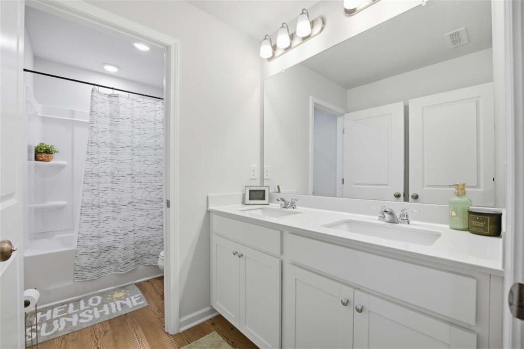7129 Timberland Trail Lithonia, GA 30058 - Photo 33 of 43 a bathroom with a sink a double vanity and a mirror