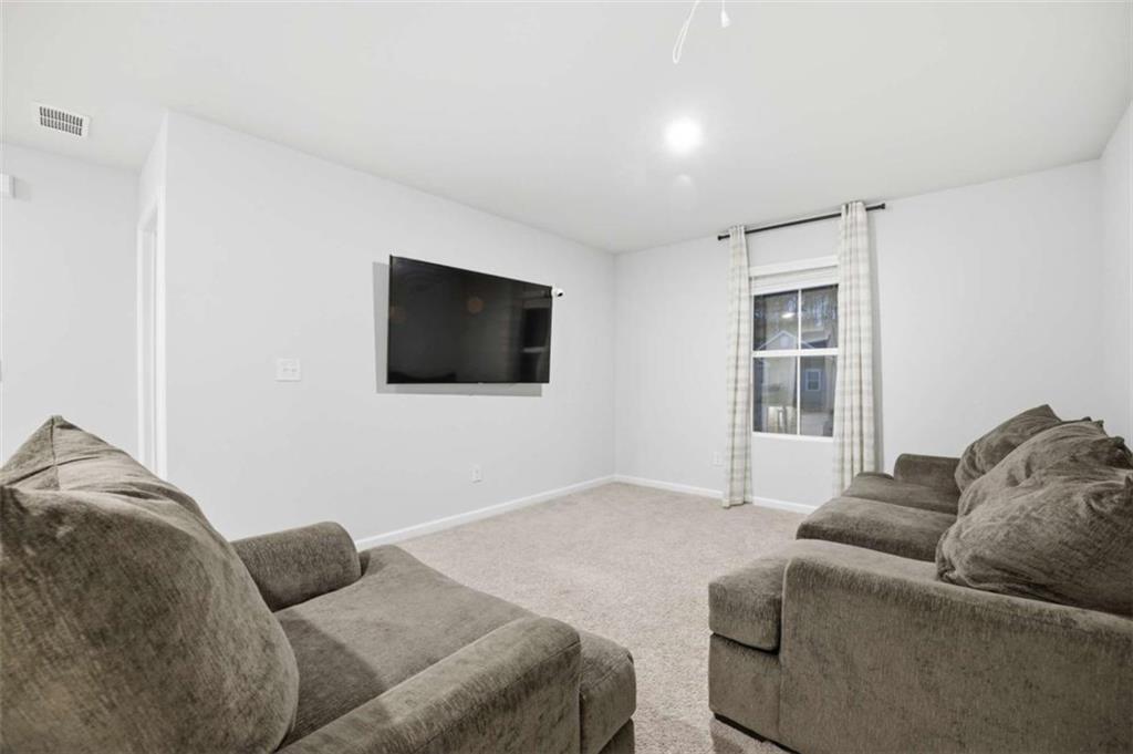 7129 Timberland Trail Lithonia, GA 30058 - Photo 34 of 43 a living room with a couch and a flat screen tv