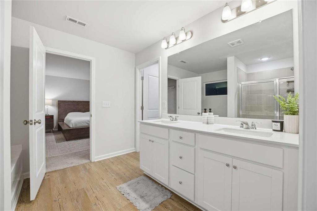 7129 Timberland Trail Lithonia, GA 30058 - Photo 40 of 43 a en suite bathroom with double sink and a mirror