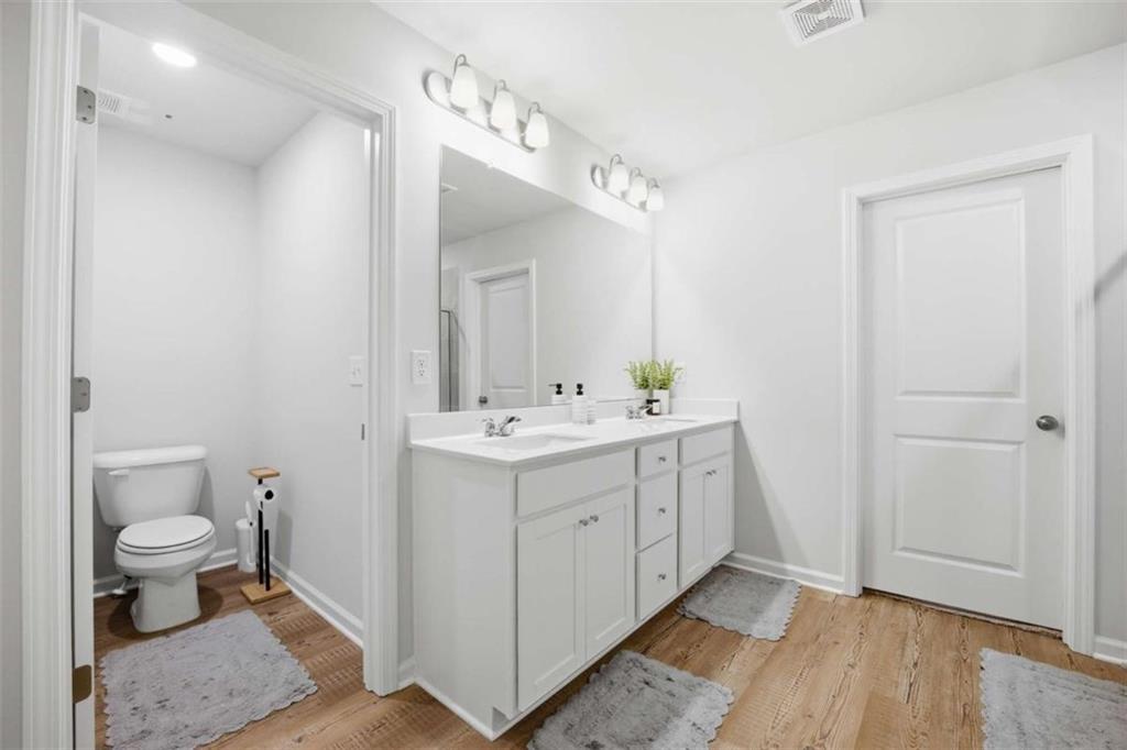 7129 Timberland Trail Lithonia, GA 30058 - Photo 43 of 43 a spacious bathroom with a double vanity sink toilet and a mirror