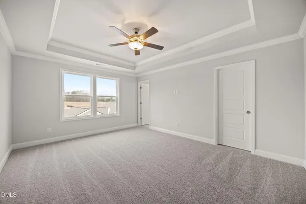 a view of empty room with wooden floor and ceiling fan