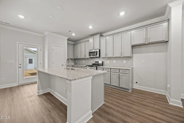 a kitchen with stainless steel appliances granite countertop a sink a stove and a refrigerator