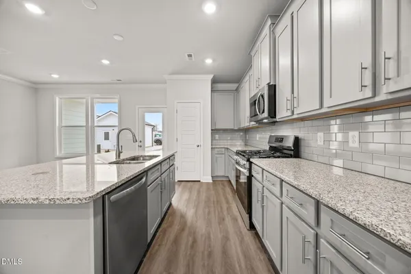 a kitchen with granite countertop white cabinets and appliances