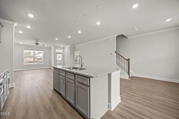 an empty room with wooden floor chandelier and windows