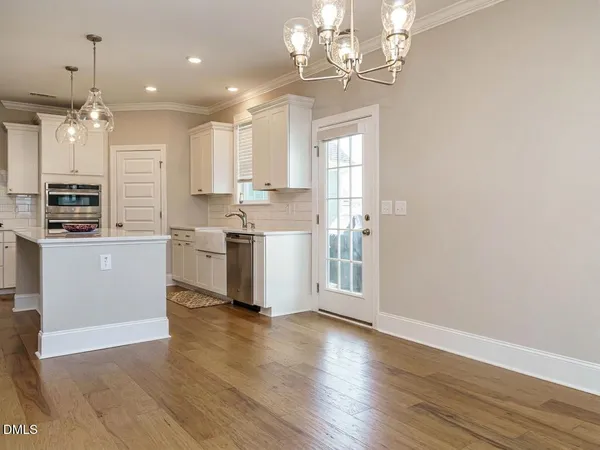 an empty room with wooden floor fireplace and windows