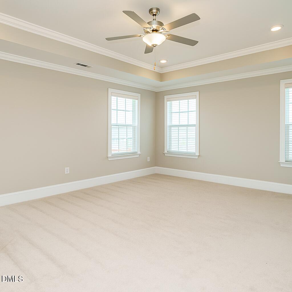 507 Dungannon Loop Clayton, NC 27520 - Photo 18 of 36 an empty room with windows and ceiling fan