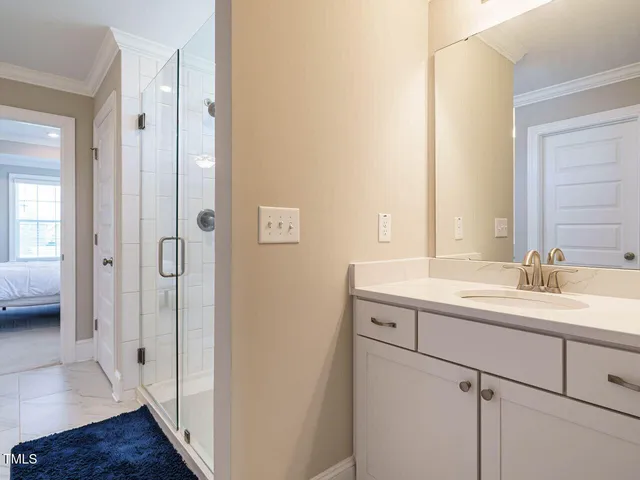 a en suite bathroom with a double vanity sink a mirror and a shower