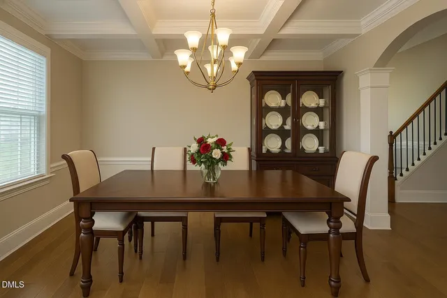 a view of a dining room with furniture a chandelier and wooden floor