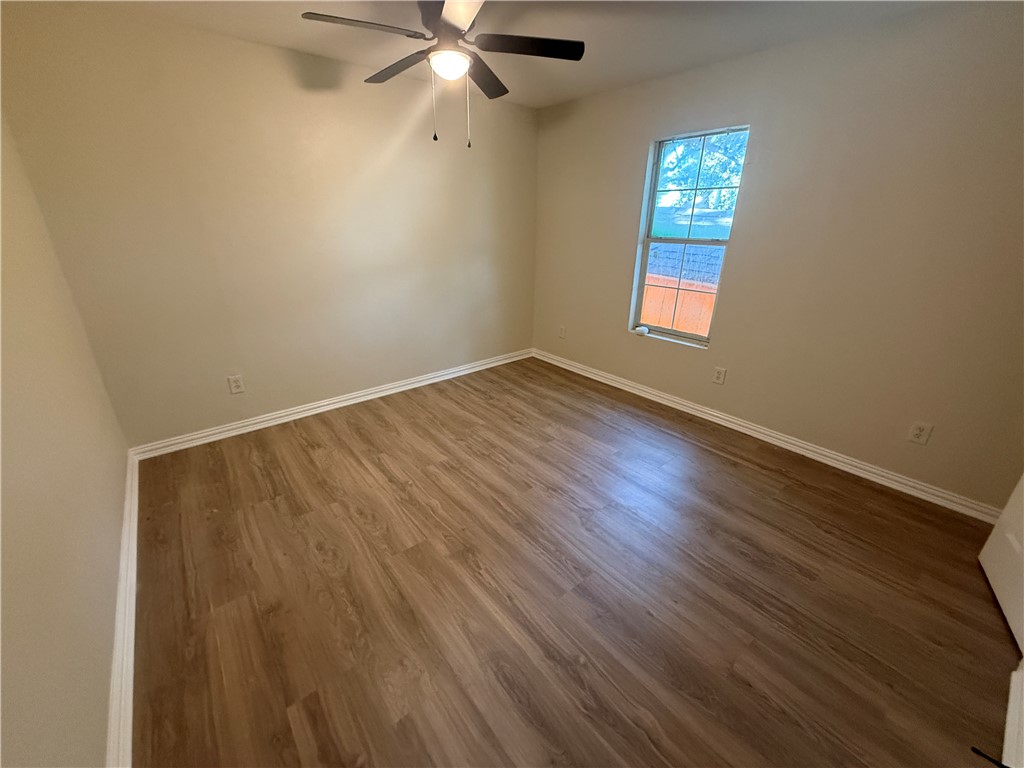 1613 Robeson Street Bryan, TX 77803 - Photo 13 of 18 an empty room with wooden floor fan and windows