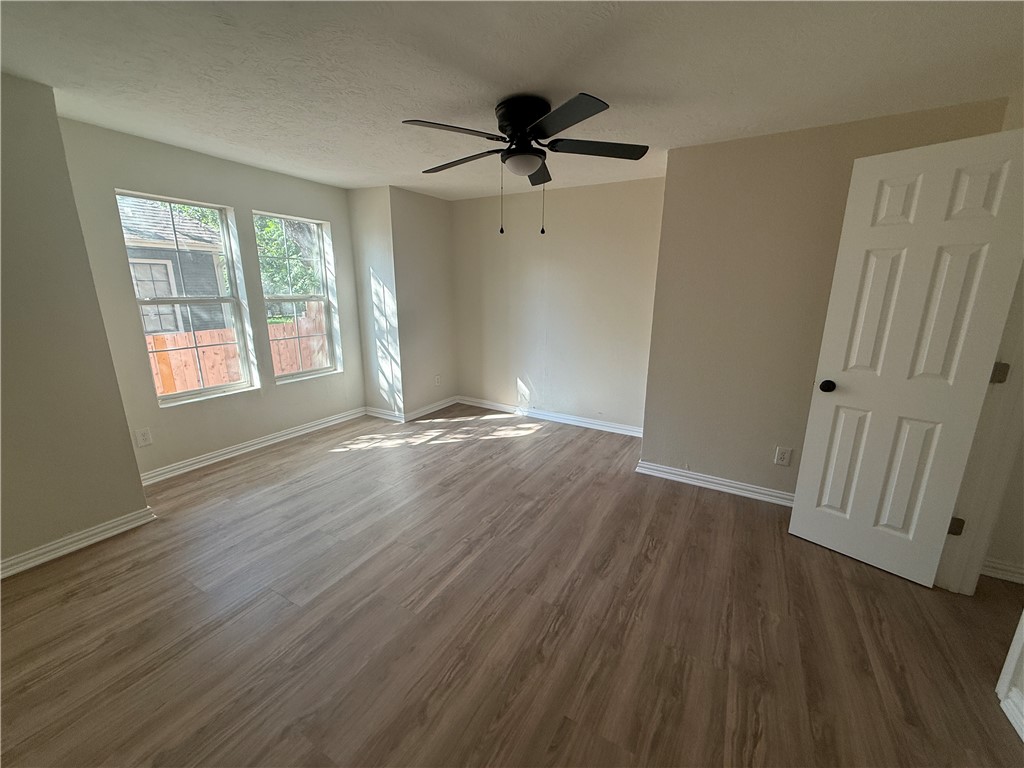 1613 Robeson Street Bryan, TX 77803 - Photo 6 of 18 a view of an empty room with wooden floor and a window