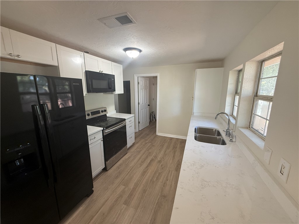 1613 Robeson Street Bryan, TX 77803 - Photo 7 of 18 a kitchen with stainless steel appliances a refrigerator sink and microwave