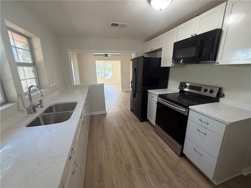 1613 Robeson Street Bryan, TX 77803 - Photo 9 of 18 a kitchen with granite countertop a refrigerator stove and sink