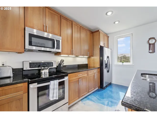 a kitchen with stainless steel appliances granite countertop a stove a sink dishwasher a refrigerator and a microwave