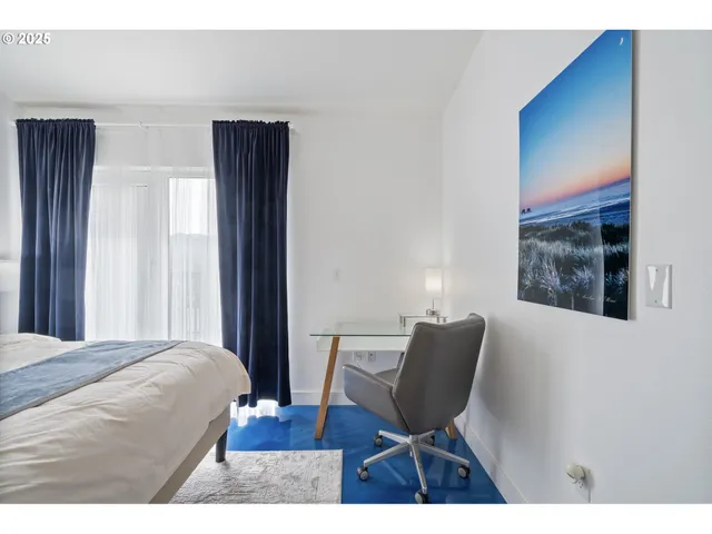 a bedroom with a chair and wooden floor